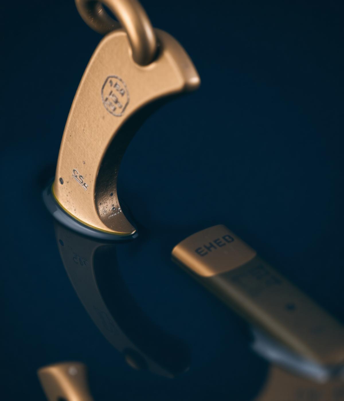 Brass anchor reflecting on still dark water